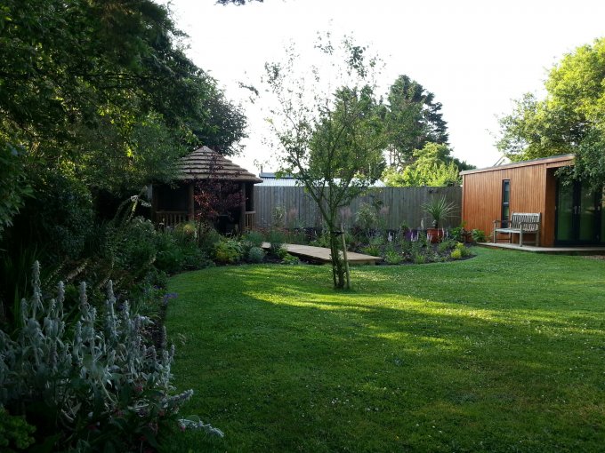 Modern wooden cabin and gazebo in garden